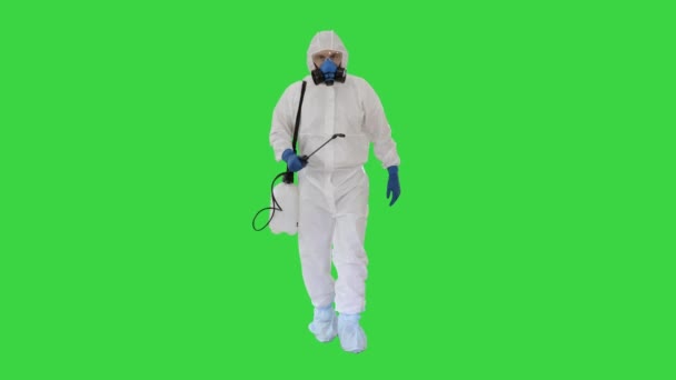 Desinfectante caminando con tanque líquido antiviral mirando a la cámara en una pantalla verde, Chroma Key . — Vídeo de stock