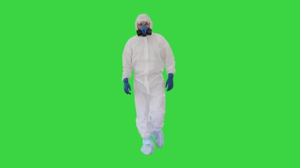 Egy férfi védőruhát visel, zöld vásznon sétál, Chroma Key. — Stock videók