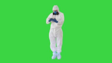 Koruyucu kıyafetli bir erkek doktor yeşil ekranda dijital tablet kullanıyor, Chroma Key.