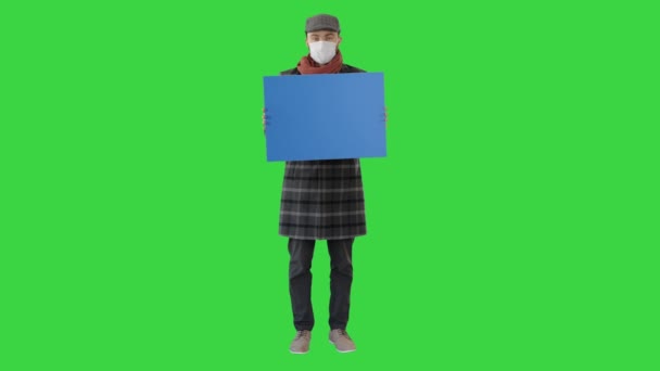 Uomo in un vestito alla moda e maschera medica con cartello bianco su uno schermo verde, Chroma Key . — Video Stock