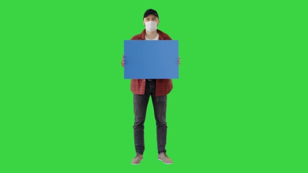 Ung man i ledig slitage håller kopia utrymme ombord på en grön skärm, Chroma Key. — Stockvideo