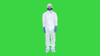 Koruyucu takım elbiseli bir adam, bir maske ve solunum cihazı Yeşil Ekran 'da, Chroma Key.