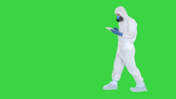 緑の画面、クロマキー上のデジタルタブレット上で動作するハズマットスーツを身に着けている医療従事者. — ストック動画