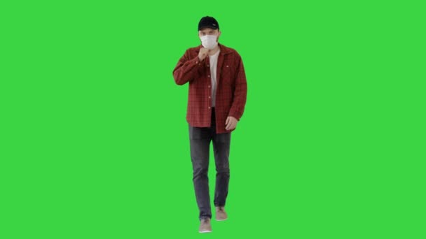 Erwachsener Bauer mit medizinischer Maske hustet beim Gehen auf einem Green Screen, Chroma Key. — Stockvideo