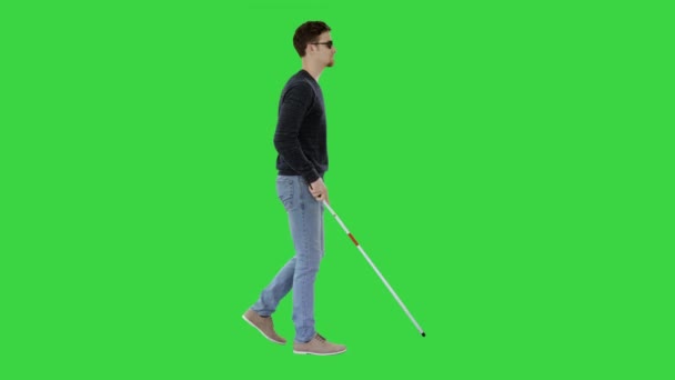 Слепой молодой человек с тростью, идущий по зеленому экрану, хрома-ключ . — стоковое видео