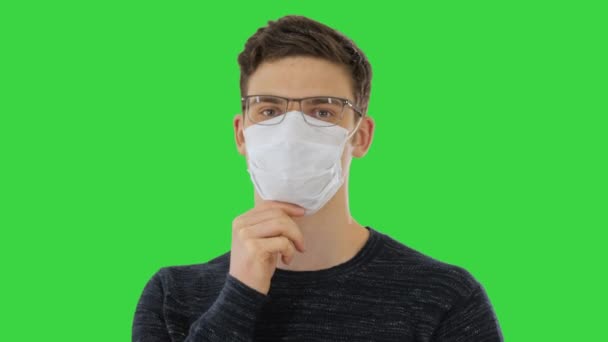 Tek kullanımlık maskeli ve gözlüklü bir adam yeşil ekranda, Chroma Key. — Stok video