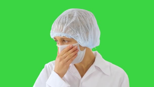 Βήχας θηλυκό γιατρός σε μια μάσκα για να αποτρέψει άλλους από τη μόλυνση σε μια πράσινη οθόνη, Chroma κλειδί. — Αρχείο Βίντεο
