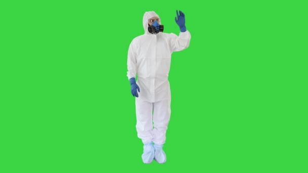 Arzt in Hazamat-Kleidung zeigt auf imaginären Bildschirm auf einem Green Screen, Chroma Key. — Stockvideo