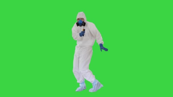 ジェームズボンドパロディー医師は、緑の画面、クロマキー上の温度をチェックする生化学保護スーツと手袋を身に着けている. — ストック動画