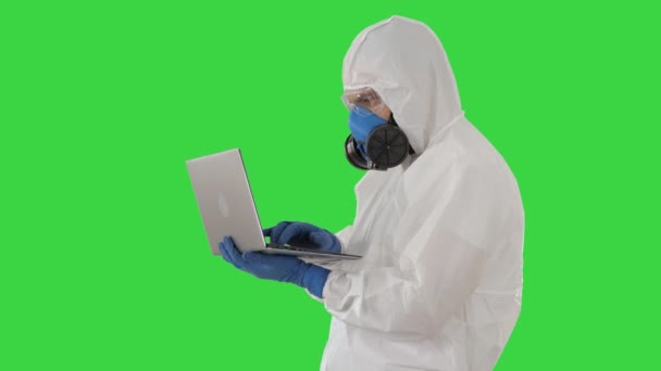 Lekarz w białym mundurze ochronnym korzystający z laptopa na zielonym ekranie, Chroma Key. — Wideo stockowe