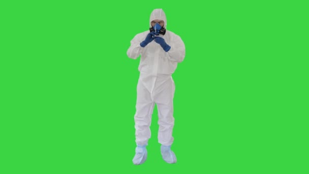 Läkare i hazmat skydd med glasögon och respirator använder spruta på en grön skärm, Chroma Key. — Stockvideo