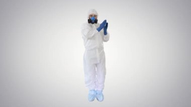 Hazamat koruyucu giysili doktor arka plan üzerinde komik bir Covid-19 konseptiyle dans ediyor..