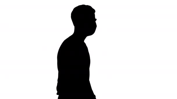 Silhouette Joven hombre guapo caminando con máscara médica en . — Vídeo de stock