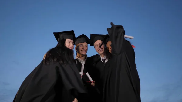 Ευτυχισμένοι απόφοιτοι φοιτητές πολυεθνική ομάδα αγκαλιάζει και κάνει — Φωτογραφία Αρχείου