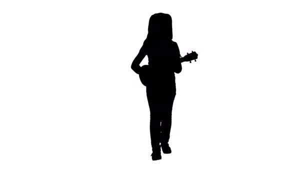 Silhouette kislány énekel és gitározik miközben a kamera felé sétál. — Stock videók