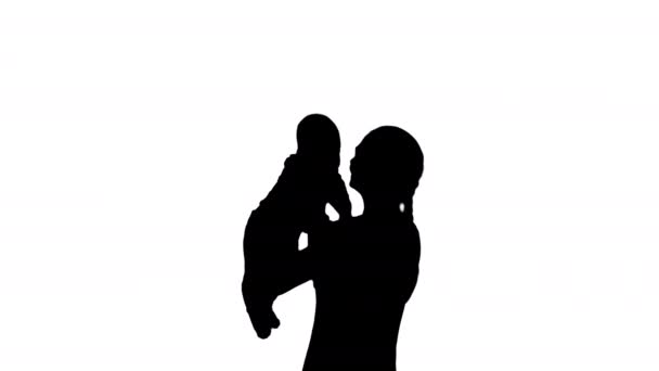 Silhouette Junge Mama spielt mit Baby, indem sie es aufrichtet. — Stockvideo