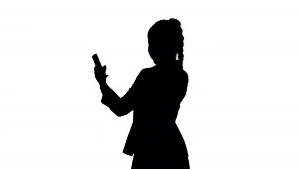 Silhouette Businessfrau schaut ins Smartphone und tanzt. — Stockvideo