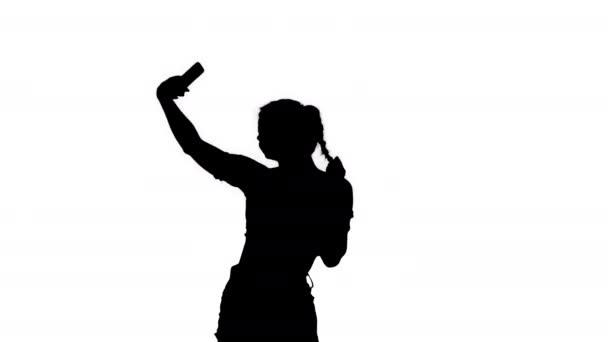 Silhouette Όμορφη νεαρή γυναίκα κάνει selfie. — Αρχείο Βίντεο