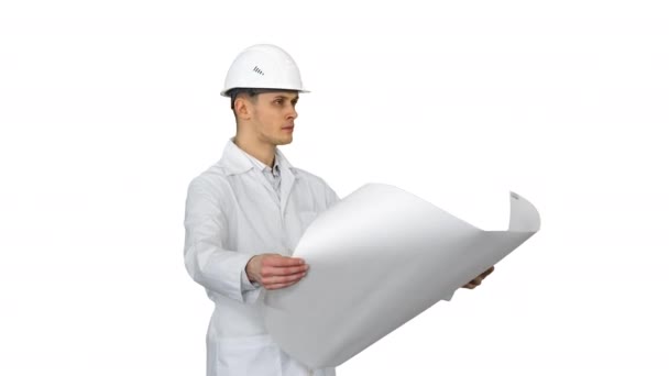 Handsome engineer, architect, builder, businessman, wearing a white helmet holding a project in his hand, looking at the object and dancing on white background. — Stock Video