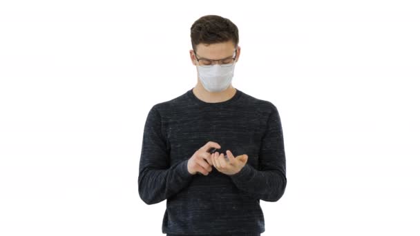 Coronavirus Mann mit Schutzmaske reinigt seine Hände mit Desinfektionsmittel auf weißem Hintergrund. — Stockvideo
