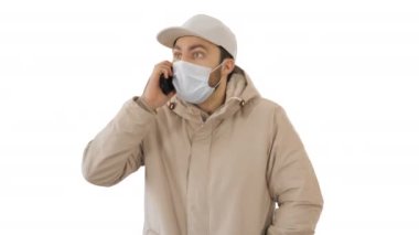 Avrupalı genç adam arıyor, beyaz arka planda yüzünde tıbbi maske var..