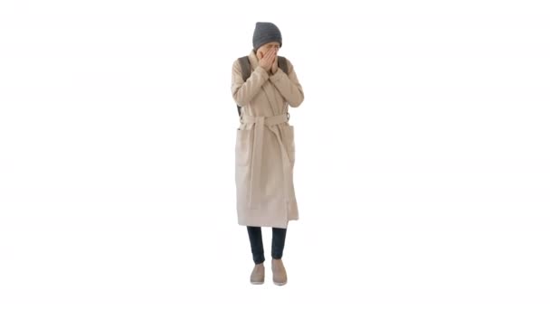 Vrouw in een jas wandelen en hoesten op witte achtergrond. — Stockvideo