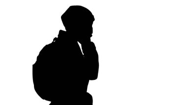 Siluet maskeli kadın yürüyor ve birine telefonla sesleniyor..
