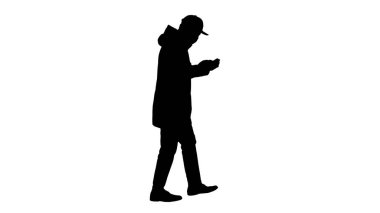 Siluet, tıbbi maskeli beyaz adam yürüyor ve telefonu kullanıyor..