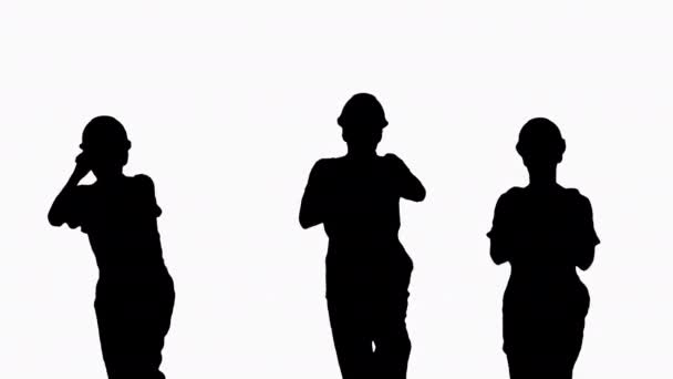 Silhouet Drie dansende bouwvakkers met harde hoeden. — Stockvideo