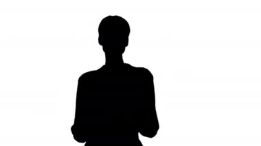 Kısa saçlı, resmi kıyafetler giyen, elinde tabletle kamerayla konuşan siluet kadın..