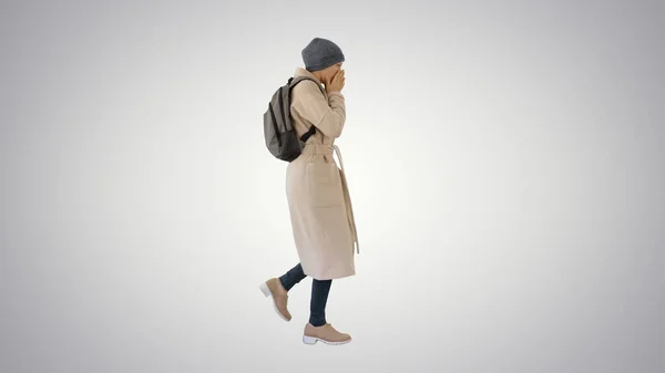 Mujer con mochila en ropa al aire libre caminando y tosiendo sobre fondo degradado . — Foto de Stock