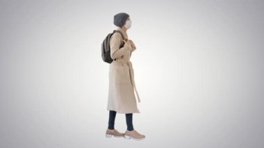 Covid-19 virüsünün önlenmesi, yüzüne tıbbi maske takan bir kadın değişken arka planda yürüyor..