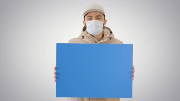 Uomo casual con cartellone spazio copia indossando maschera protettiva su sfondo sfumato . — Video Stock