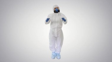 Hazamat kostümlü erkek doktor, arka planda zafer işaretleri yapıyor..