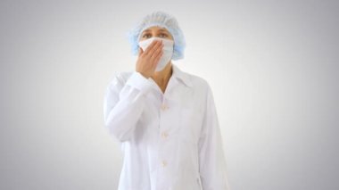 Doktor kadın boğaz ağrısı ve grip belirtileriyle kendini hasta hissediyor. Ağzı değişken arka planda öksürüyor..