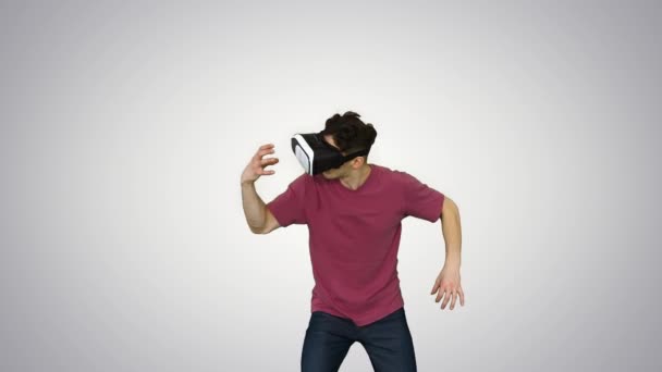 Erstaunter Mann mit VR-Headset-Brille berührt und interagiert mit Virtual-Reality-Welt auf Gradienten-Hintergrund. — Stockvideo