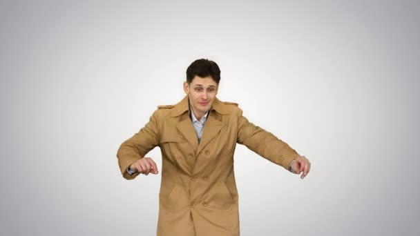 Молодий чоловік в тренч пальто танцює і розважається на градієнтному фоні . — стокове відео