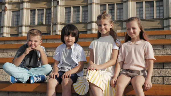 Grupo de crianças pré-escolares sorrindo para a câmera sentados juntos . — Fotografia de Stock