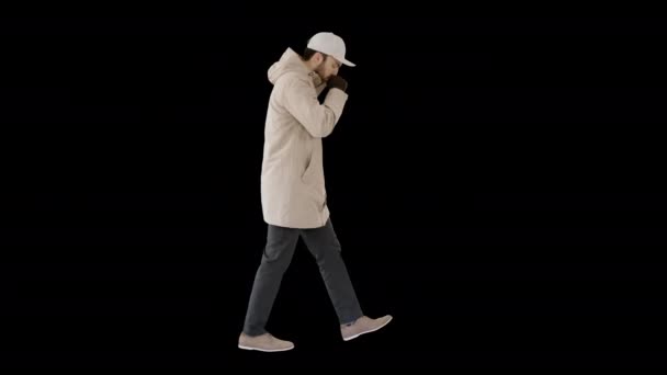 Caucasian man in a hat and coat coughing walking, Alpha Channel — Stock Video