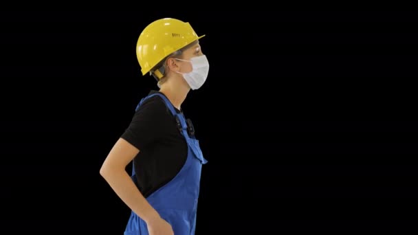 Trabalhadora da construção feminina em macacão e em caminhada máscara médica, Canal Alpha — Vídeo de Stock