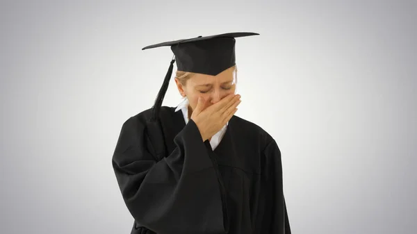 Studente laureato bionda in piedi e tosse su sfondo gradiente . — Foto Stock