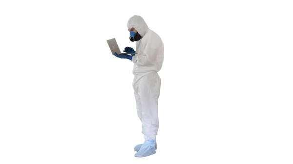 Médico con uniforme protector blanco usando portátil sobre fondo blanco . — Foto de Stock