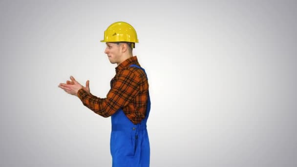 Stavební dělník dělá otočit a složí ruce při pohledu do kamery Nejlepší stavební koncept na gradient pozadí. — Stock video