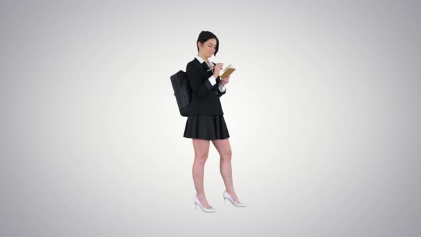 Pretty student with backpack writing notes on gradient background. — Stock Video