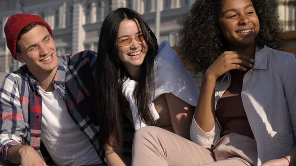 Skupina multiraciálních mladých přátel, kteří diskutují venku. — Stock fotografie