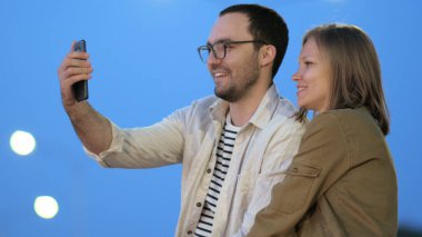 Geceleri şehirde eğlenceli bir çift selfie çekiyor..