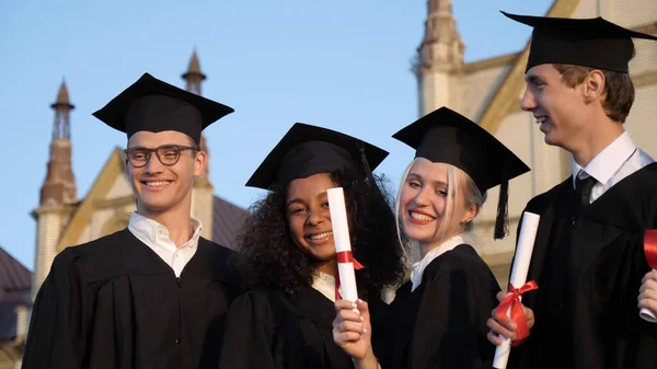 Studenten die glimlachen en lachen met diploma 's afstuderen. — Stockfoto