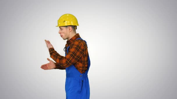 Trabalhador da construção engraçado fazendo um flip e perde chapéu de segurança no fundo gradiente . — Vídeo de Stock
