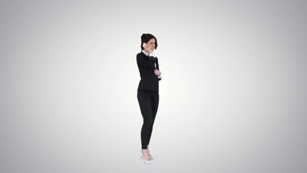 Mulher de negócios dançando depois de fazer uma chamada de sucesso no fundo gradiente . — Vídeo de Stock