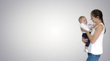 Genç anne bebeğini elinde tutuyor ve yürüyor, Alfa Kanalı.